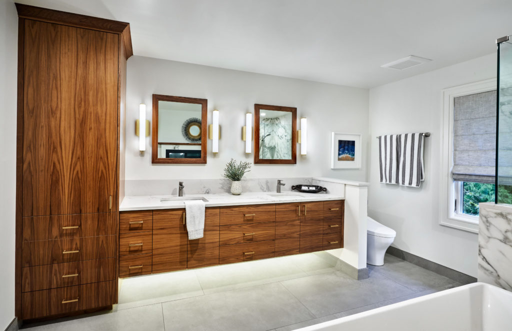 primary bath walnut vanity with quartz countertops and framed mirrors