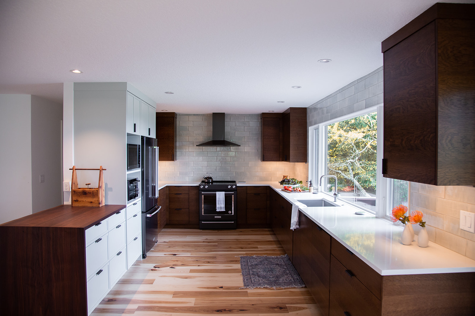 overall view of the kitchen with stained oak cabinets and handmade tile backsplash