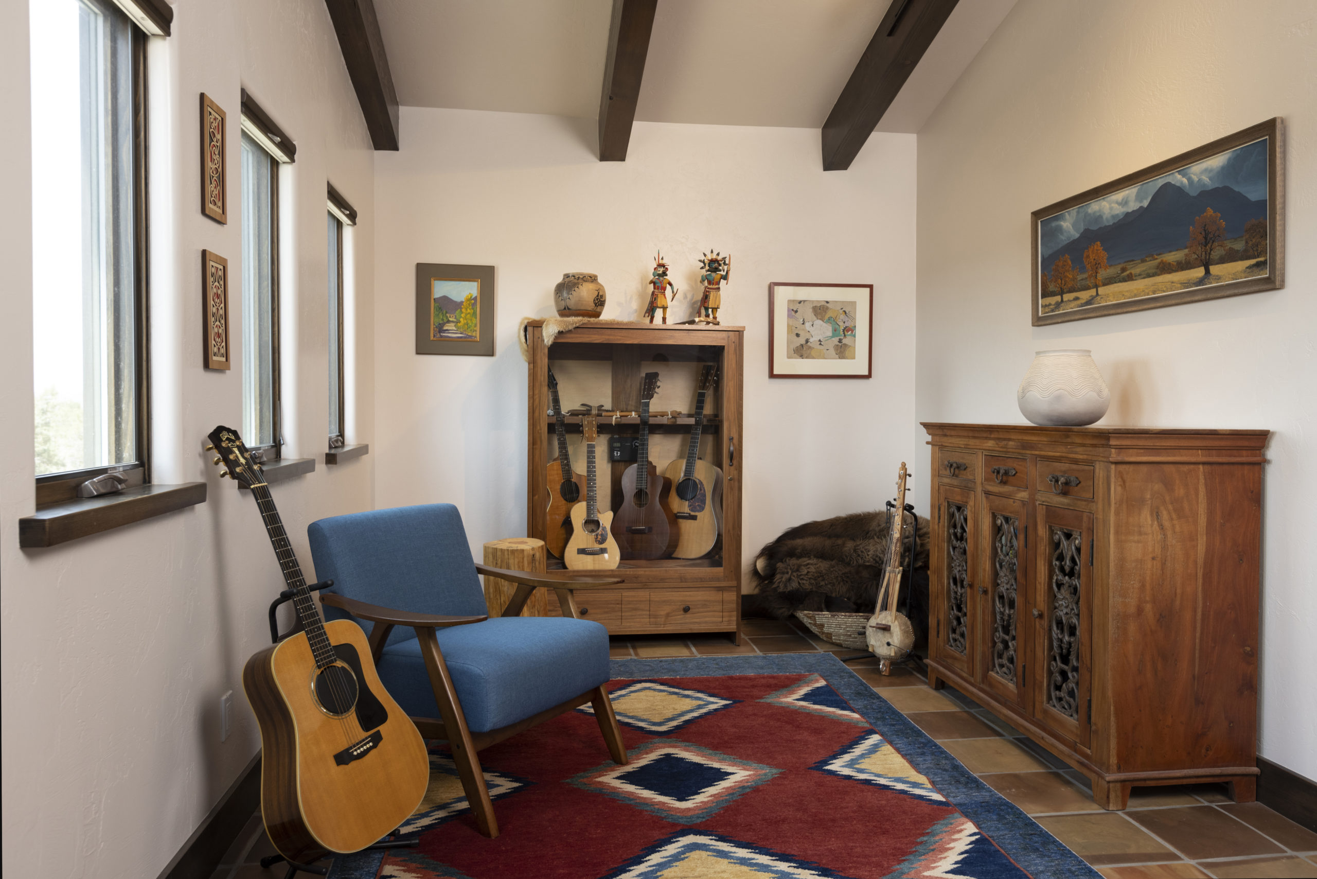 music room with custom guitar cabinet and Navajo rugs, sleeping Ute painting