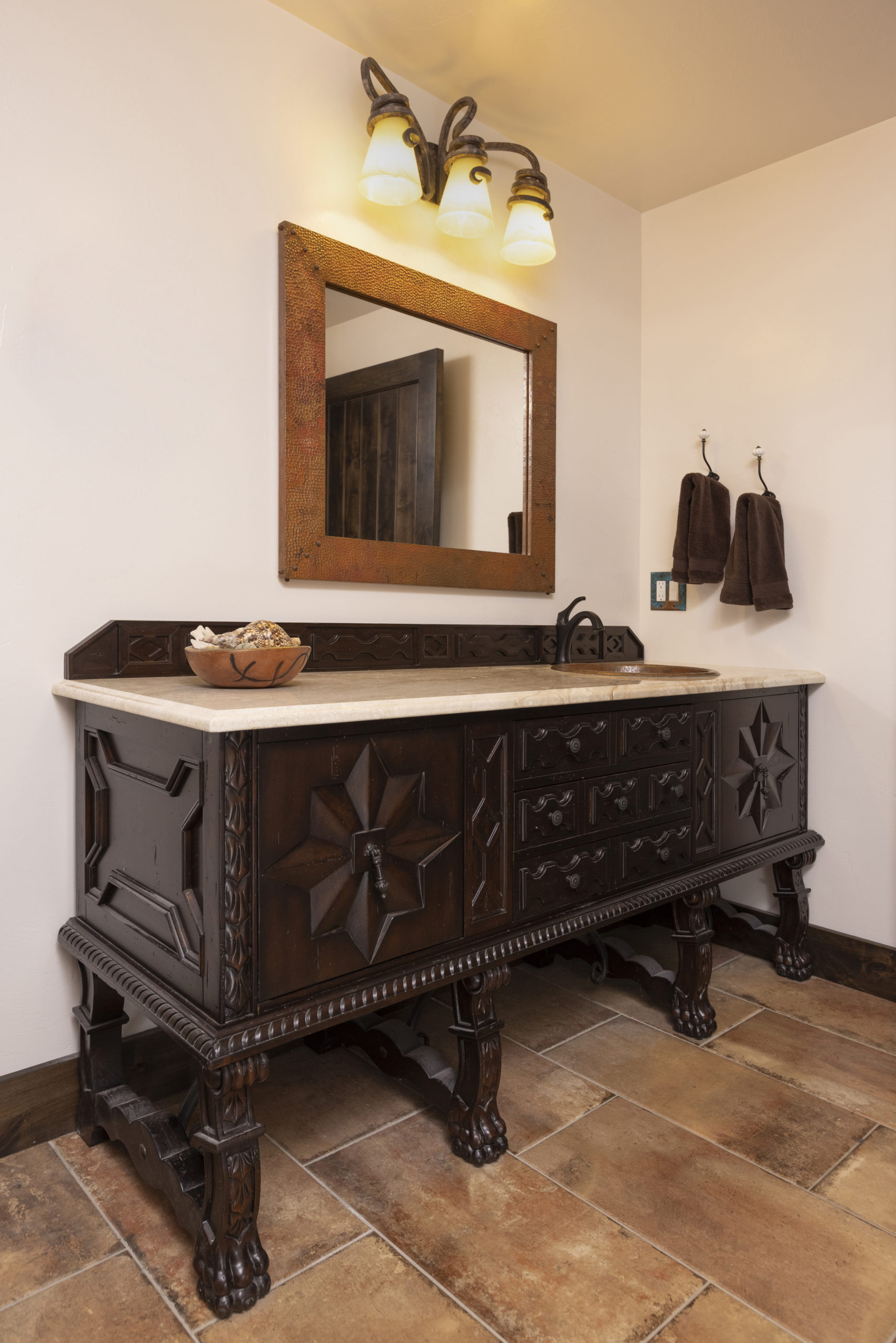 guest bath with custom carved wood vanity, copper sink and copper mirror