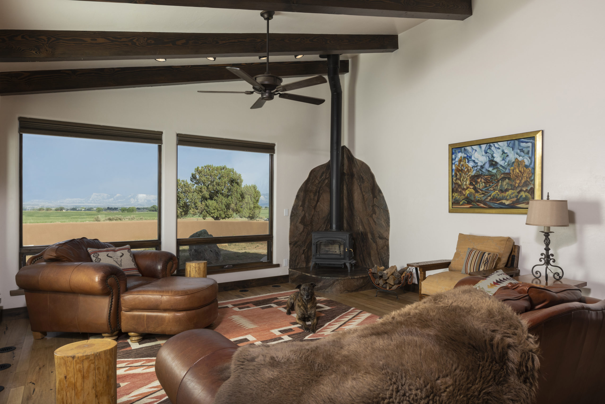 Living room with mountain views and custom stone fireplace surround, wood burning stove