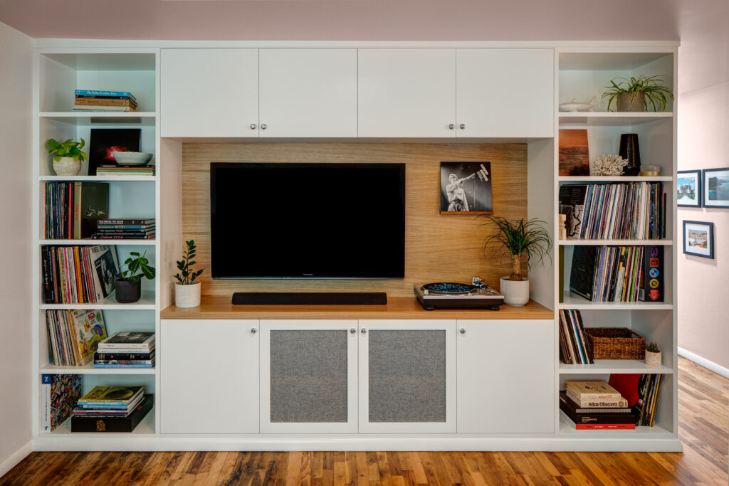 Media wall with custom cabinets, record storage, wood and white cabinetry.