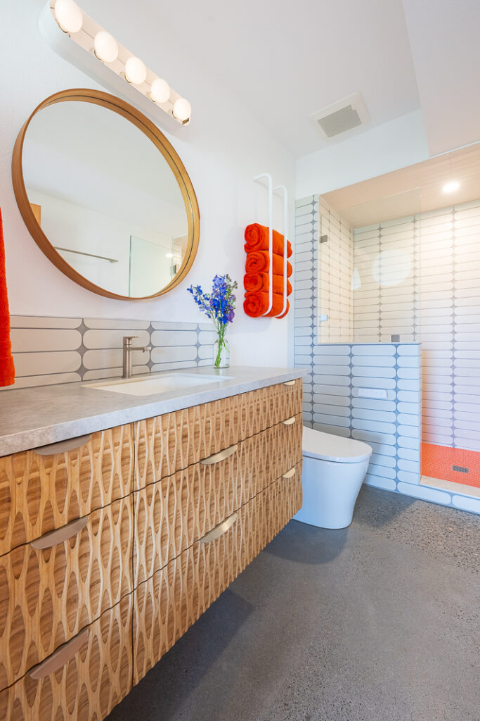 modnern bathroom with custom plyboo vanity and pops of orange