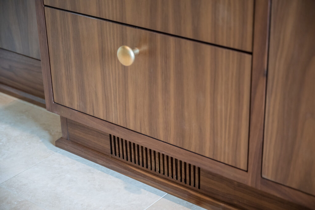 walnut vanity with integrated heat register in toe kick, brass hardware